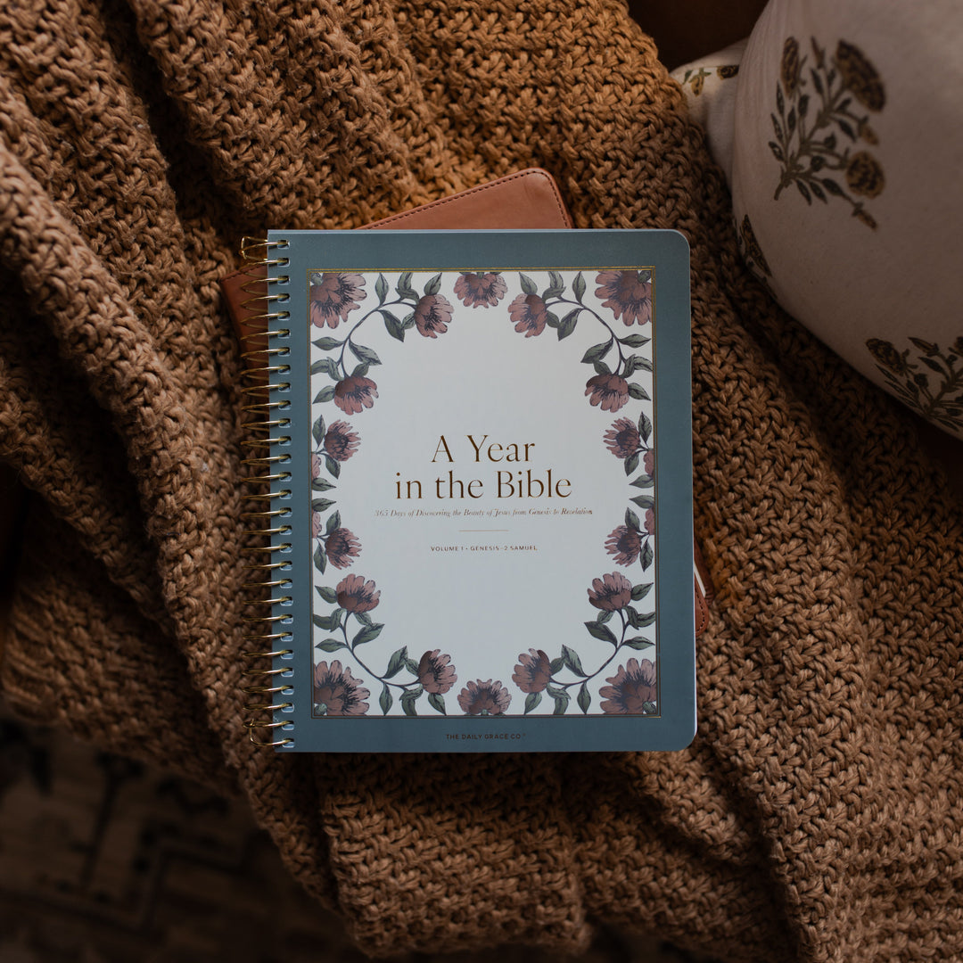A Year in the Bible spiral cover on a leather bible on a brown knitted blanket