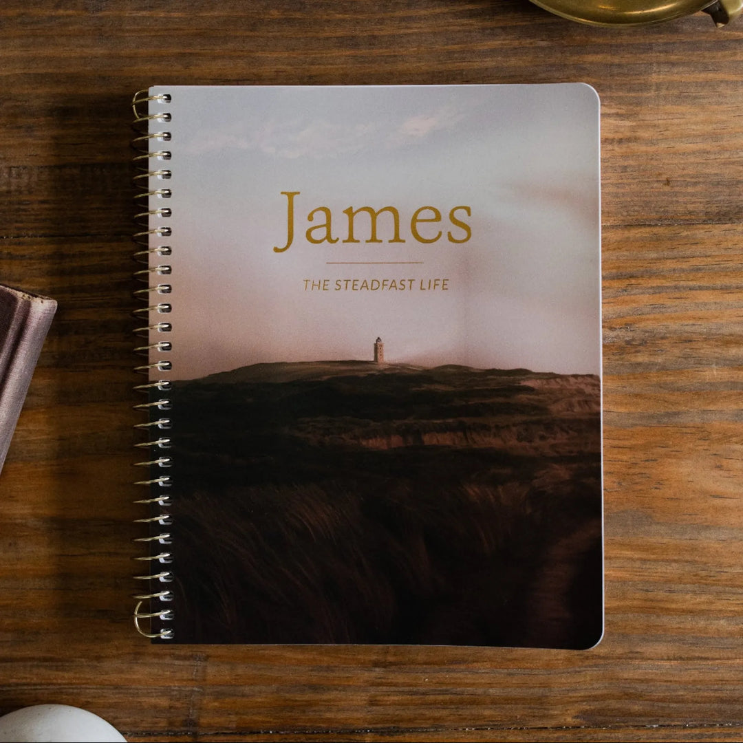 James Men's Spiral study Cover on a wooden table next to a bronze oil lamp