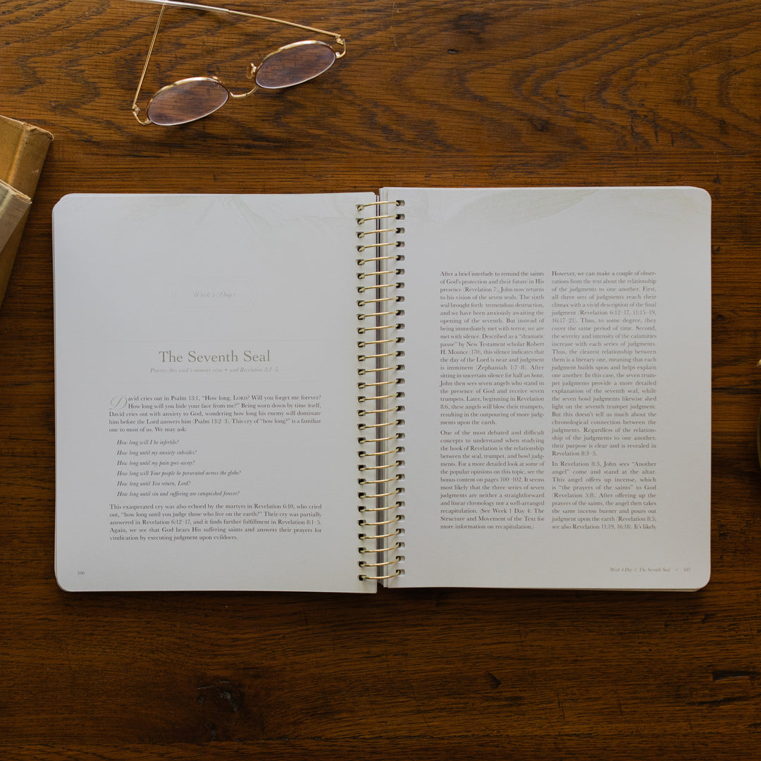 Revelation Spiral Study opened to page 106, the Seventh Seal, on a wooden table next to a pair of glasses